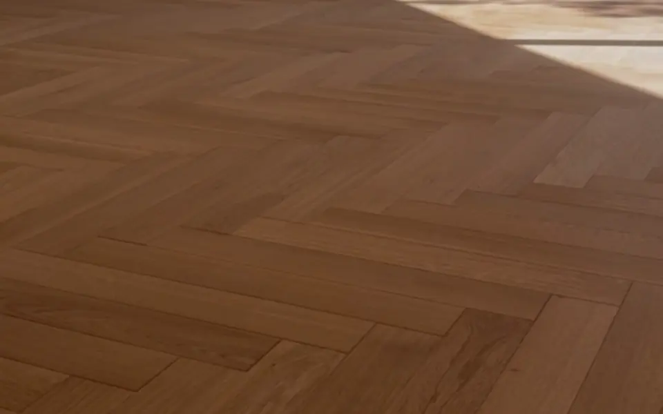 Parquet à chevrons dans une pièce éclairée par la lumière d’une fenêtre