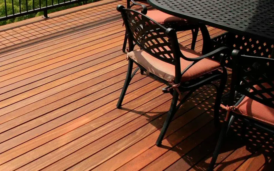 Terrasse en lames de bois rainurées avec un tabouret et des plantes en pot