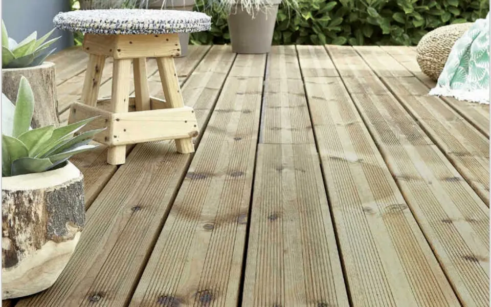 Terrasse en bois rouge avec une table et des chaises en fer forgé
